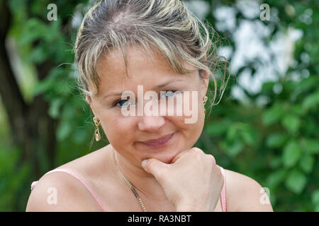 Glücklich lächelnde Frau mittleren Alters Porträt mit Natur Hintergrund Stockfoto