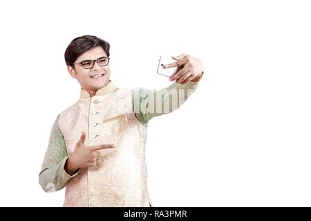 Junge Inder, die mit mobilen selfie Stockfoto