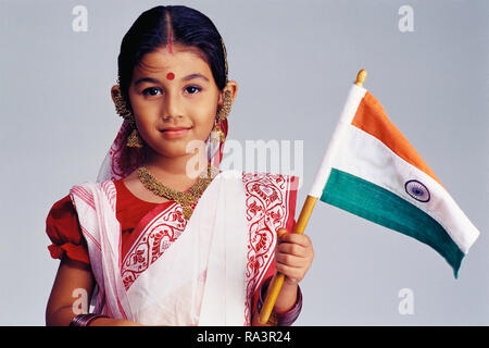 Porträt EINES BENGALI MÄDCHEN MIT TRADITIONELLEN SAREE, HALTEN DIE INDISCHE FLAGGE Stockfoto