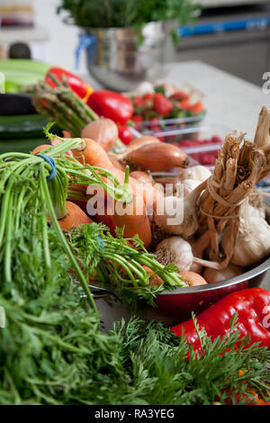 Frische Zutaten Gemüse in einer Küche mit Karotten, Knoblauch, Ingwer und Pfeffer Vorbereitung Stockfoto