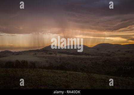 Regen auf einem fernen Berg mit orange Sonnenuntergang Stockfoto