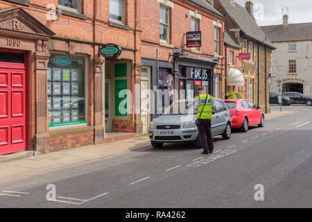 Civil enforcement officer Kontrolle möglicher illegaler Parkplatz, in ausgewiesenen Behindertenparkplätzen. Rutland, England, Großbritannien Stockfoto