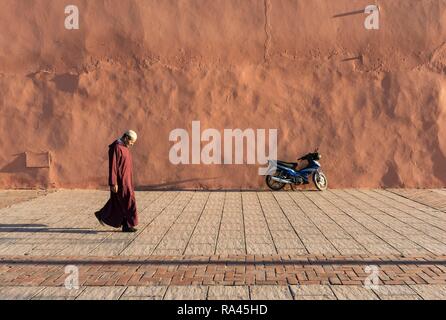 Mann Spaziergänge entlang der rot-orange Stadtmauer von Marrakesch, Marokko Stockfoto