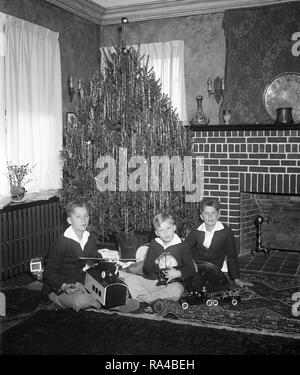 Diese glücklichen jungen über Ihren Weihnachtsbaum gruppiert sind George, Jr., Clarkes und Friedrich, die Söhne von Herrn und Frau George Akerson. Herr Akerson ist Präsident Hoover Sekretär Ca. 1930 Stockfoto