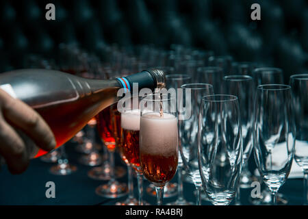 Gläser, Wein in Gläser gießen. Barkeeper in Gläser gießen rot Champagner Stockfoto