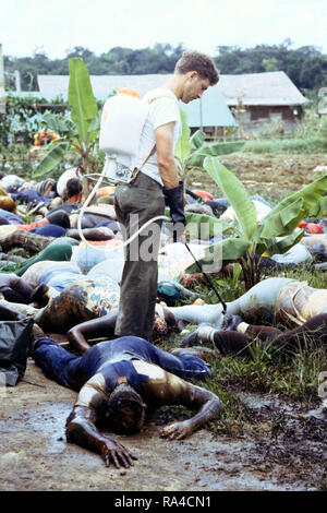 1978 - Mitglied der US-Armee sprays Desinfektionsmittel in den Körpern von Jonestown Opfer, bevor Sie sie in Kunststoff Beutel für Ausbau von Georgetown. Stockfoto