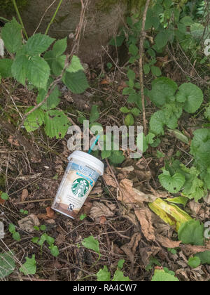 Abgenutzte Starbucks Kaffee Tasse zum Mitnehmen aus Kunststoff in Cornwall Hecke am Straßenrand gesehen verworfen. Krieg auf Kunststoff, Kunststoff Umweltverschmutzung, die Umwelt zu belasten. Stockfoto