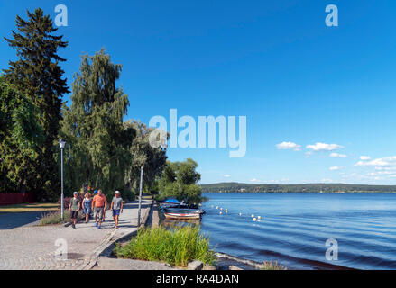 Touristen zu Fuß entlang der Ufer des Sees Norasjön in der Stadt Nora, Örebro Län, Västmanland, Schweden Stockfoto