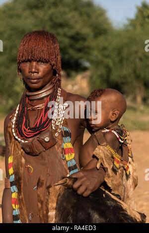 Frau mit Baby aus dem Hamer Stamm in traditioneller Kleidung, Turmi, südlichen Nation, Region, Äthiopien Stockfoto