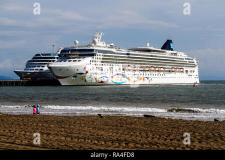 Kreuzfahrtschiffe am Pier in Puntarenas, Puerto Caldera, Costa Rica. NCL's Norwegian Star im Vordergrund. Stockfoto