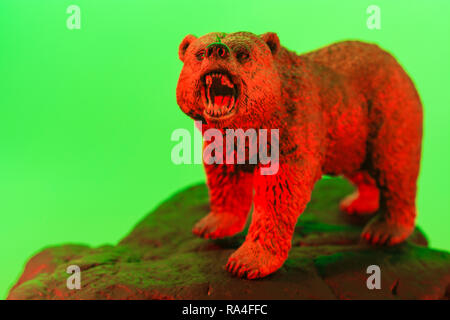 Spielzeugbär steht auf Stein vor einfarbigem Hintergrund, alle Farbe beleuchtet. Für den Bärenmarkt sind die Marktbären, die Börsenbärte, die Besessenheits- und Marktcrash 2020 Stockfoto