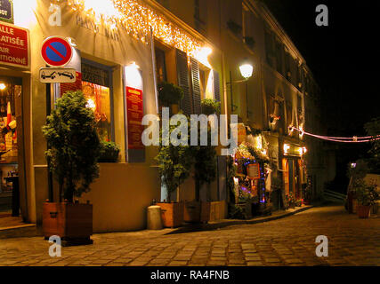 Rue Poulbot, Montmartre, Paris, Frankreich in der Nacht: Kopfsteinpflaster und Cafés Stockfoto