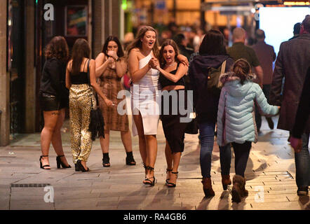 Nachtschwärmer in St. Mary's Street in Cardiff in das Neue Jahr feiern. Stockfoto