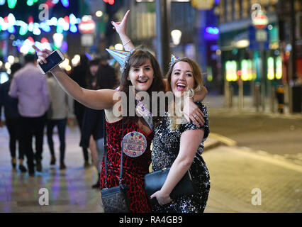 Nachtschwärmer in St. Mary's Street in Cardiff in das Neue Jahr feiern. Stockfoto