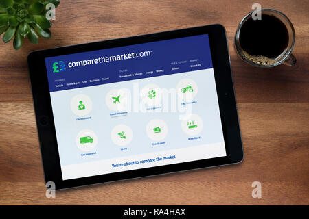 Die Website des Marktes zu vergleichen ist, auf einem iPad Tablet gesehen, auf einer hölzernen Tisch zusammen mit einem Espresso und einem Haus Anlage (nur redaktionelle Nutzung). Stockfoto