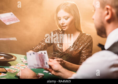 Attraktives Mädchen mit Croupier Poker Spielen im Casino, Geld auf den Tisch fallen Stockfoto