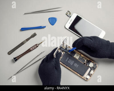 Techniker oder Ingenieur zerlegen Komponenten aufgeschlüsselt Smartphone für die Reparatur oder den neuen Teil auf dem Schreibtisch ersetzen Stockfoto