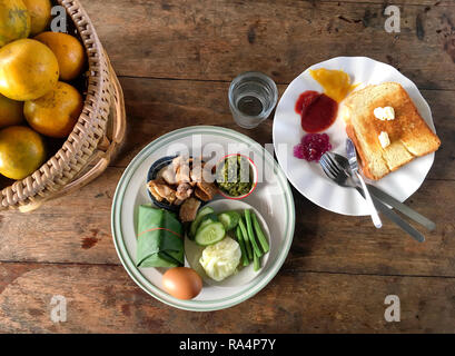 Foto von Traditionelle nordthailändische Frühstück mit Orangen und Brot auf dem Tisch Stockfoto