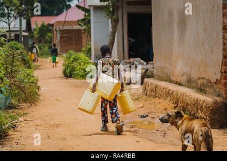 Frau, die Wasser in Entebbe, Uganda, trägt Stockfoto