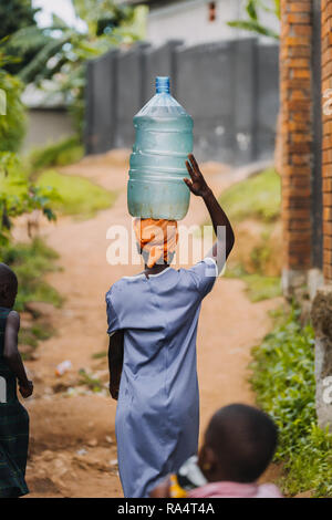Frau, die Wasser in Entebbe, Uganda, trägt Stockfoto
