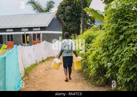Frau, die Wasser in Entebbe, Uganda, trägt Stockfoto