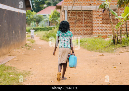Frau, die Wasser in Entebbe, Uganda, trägt Stockfoto