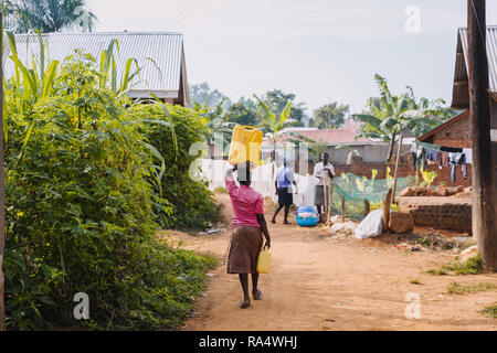 Frau, die Wasser in Entebbe, Uganda, trägt Stockfoto