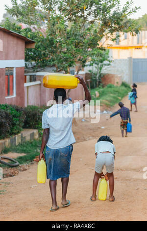Frau, die Wasser in Entebbe, Uganda, trägt Stockfoto