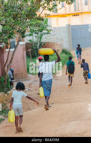 Frau, die Wasser in Entebbe, Uganda, trägt Stockfoto