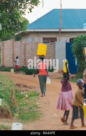Frau, die Wasser in Entebbe, Uganda, trägt Stockfoto