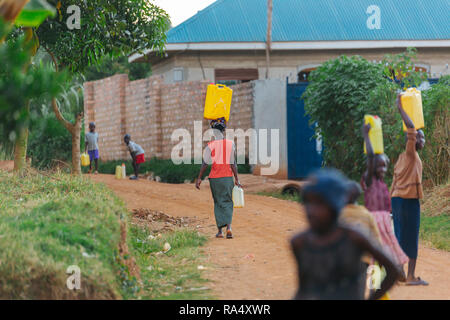 Frau, die Wasser in Entebbe, Uganda, trägt Stockfoto