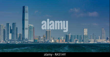 Die Wolkenkratzer von West Kowloon und Tsim Sha Tsui line Victoria Harbour in Hong Kong Stockfoto