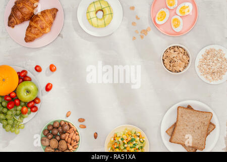 Gesundes Frühstück Zutaten auf Schwarz konkreten Hintergrund. Haferflocken, Mandeln Milch, Nüsse, Früchte und Beeren. Gesunder Lebensstil, Diät, gesund essen Stockfoto