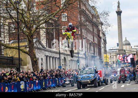 Moto Stunts internationale Motorrad display Team am Tag London New Year's Parade. Motorrad Sprung über ein Auto in Whitehall mit Nelson's Column Stockfoto