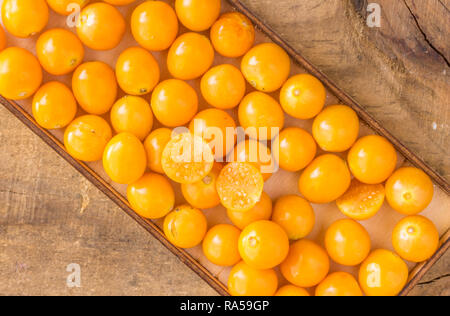 Kap Stachelbeeren in Holz- Fach auf rustikalen Holz Hintergrund - Ansicht von oben Foto Stockfoto