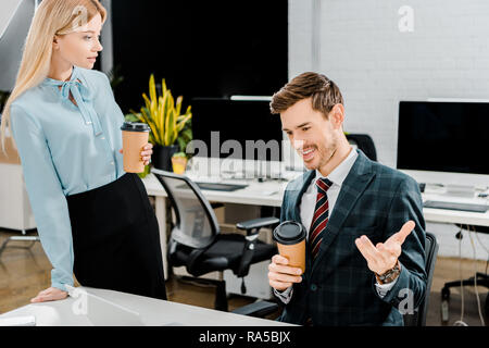 Junge Kollegen mit Kaffee zu gehen, Gespräch im Büro Stockfoto