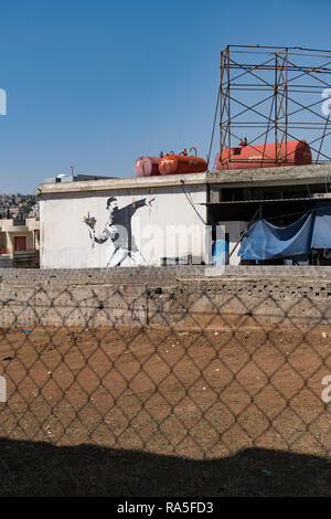 Ein wandbild von den schwer bestimmbaren Britischen Street Artist Banksy deckt eine Mauer in der West Bank Dorf Beit Sahour. Palästina Stockfoto