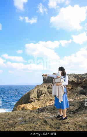 Asiatische Mutter mit ihrem Baby am Kap Zanpa Okinawa Japan Stockfoto