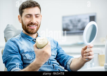 Porträt einer stattlichen bärtiger Mann mit gesunden Lächeln in der Zahnarztpraxis Stockfoto