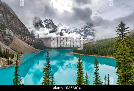 Wolken zwischen den Berggipfeln, Reflexion in der türkisfarbenen See, Lake Moraine, Rocky Mountains, Banff National Park Stockfoto