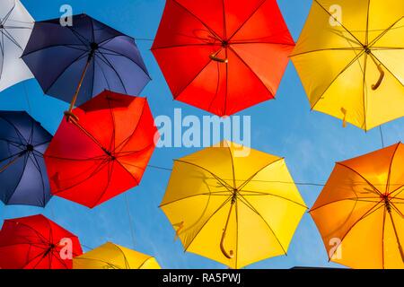 Viele bunte Sonnenschirme, Liegestühle, Sonnenschirme, hängen in der Luft, Sonnenschein vor blauem Himmel, Imst, Tirol, Österreich Stockfoto