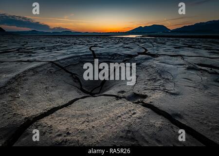 Risse, ausgetrockneten Boden mit kleinen Wasser- und Allgäuer Alpen im Hintergrund, Forggensee, Füssen, Ostallgäu, Bayern Stockfoto