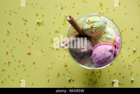 Eine Tasse Eis mit gewalzten Wafer. Eis closeup, mit gelbem Hintergrund. Stockfoto