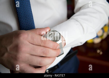 Armbanduhr auf Girl's Hand vor einem Laptop, der Männer sehen Sie an hand Stockfoto