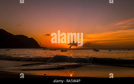 Tobago, West Indies, Karibik. Schönen Sonnenuntergang über dem Meer im Fischerdorf Castara mit Seevögeln und pelikanen Tauchen in den Ozean. Stockfoto