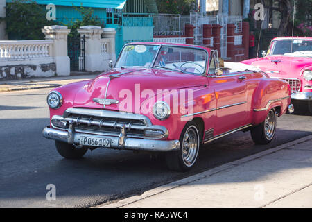 Klassischer rosafarbener amerikanischer chevrolet Deluxe cabriolet aus den 1950er Jahren, der vor verlassenen Häusern in Havanna, Kuba, Karibik, geparkt wird Stockfoto
