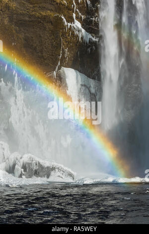 Skógafoss, einem wunderschönen Wasserfall mit einem Regenbogen im Spray, entlang des Flusses Skógá und Fallen über ehemalige Klippen, entlang der Südküste Islands i Stockfoto