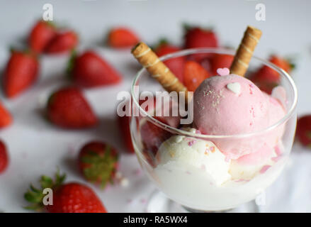 Eine Tasse Eis mit Erdbeeren und rollte Wafer. eis Nahaufnahme. Stockfoto