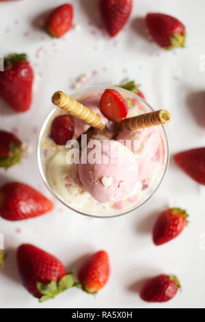 Eine Tasse Eis mit Erdbeeren und rollte Wafer. eis Nahaufnahme. Stockfoto