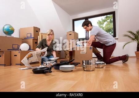 Junges Paar in einen leeren Raum in eine neue Wohnung Auspacken der ersten Boxen Stockfoto